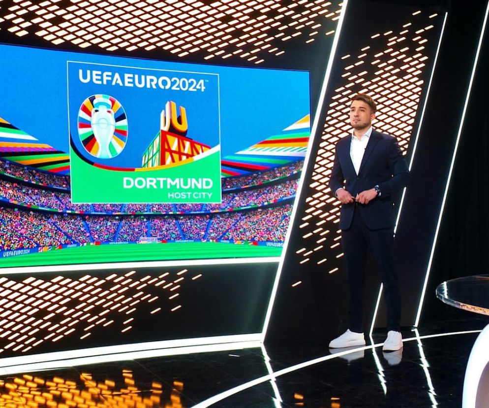 Dziennikarz Patryk Ganiek w studiu TVP Sport na tle grafiki UEFA EURO 2024. O jego życiu prywatnym przeczytasz na Eska.