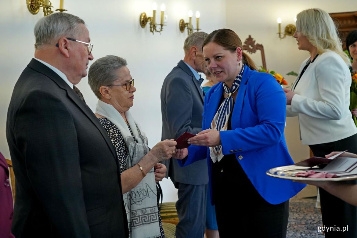 Prezydent Aleksandra Kosiorek i Agata Lipińska, zastępczyni kierownika Urzędu Stanu Cywilnego w Gdyni uhonorowały małżeństwa z długim stażem