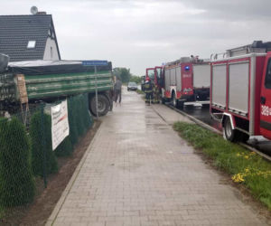 Groźna kolizja w Dąbczu. Traktor z przyczepami wjechał w dom i przewrócił się