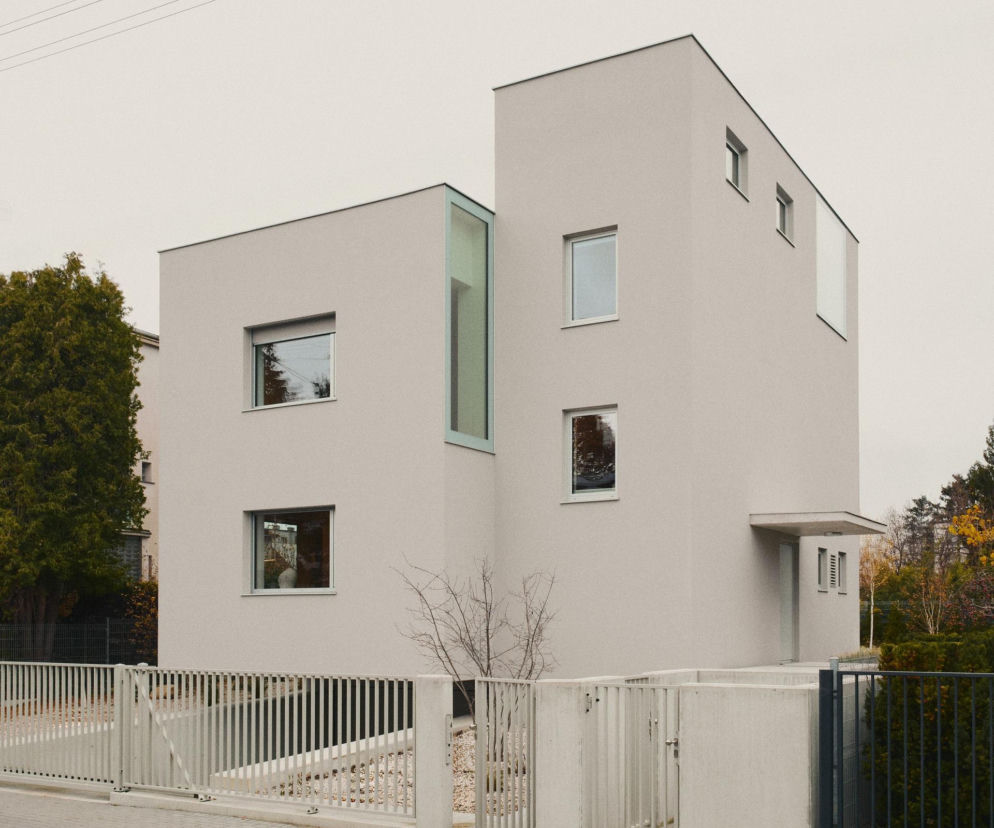 Nowoczesny dom w Gdyni Orłowie, projektu IFAgroup, o minimalistycznej formie z jasną elewacją i przeszkleniami, wpisuje się w modernistyczny charakter ulicy. To przykład architektury tła, w której światło dzienne i intymność mieszkańców są kluczowe, o czym można przeczytać na Architektura Murator Plus.