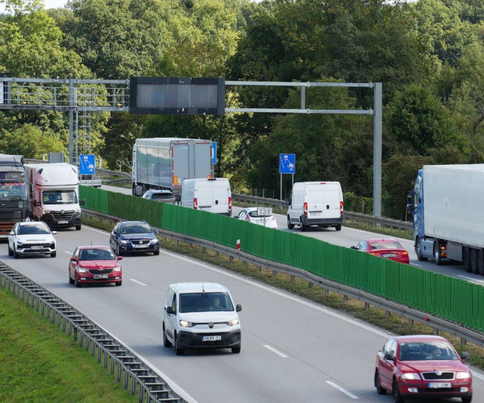 Fragment autostrady A4 z pojazdami ciężarowymi i osobowymi, symbolizujący problem odcinkowego pomiaru prędkości, który jest pułapką dla wielu kierowców. O ryzyku mandatów i zmianach w przepisach przeczytasz więcej na naszym portalu.