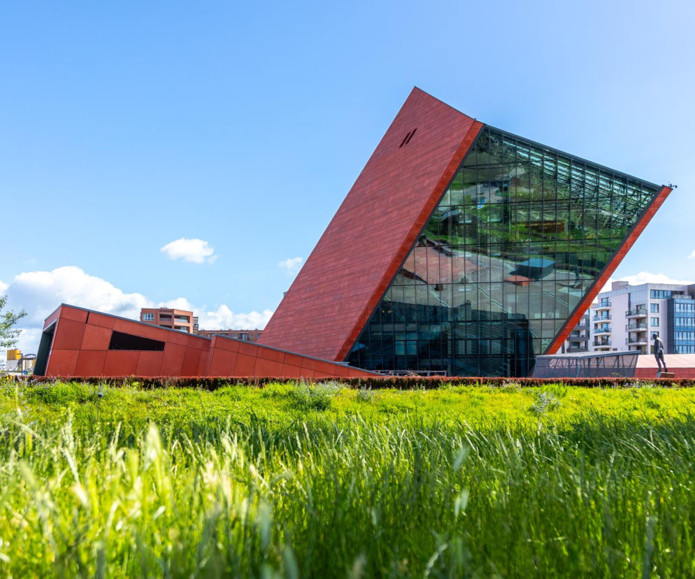 Pochylona wieża Muzeum II Wojny Światowej w Gdańsku z czerwonego betonu i szkła. O architekturze budynku czytaj na Architektura.