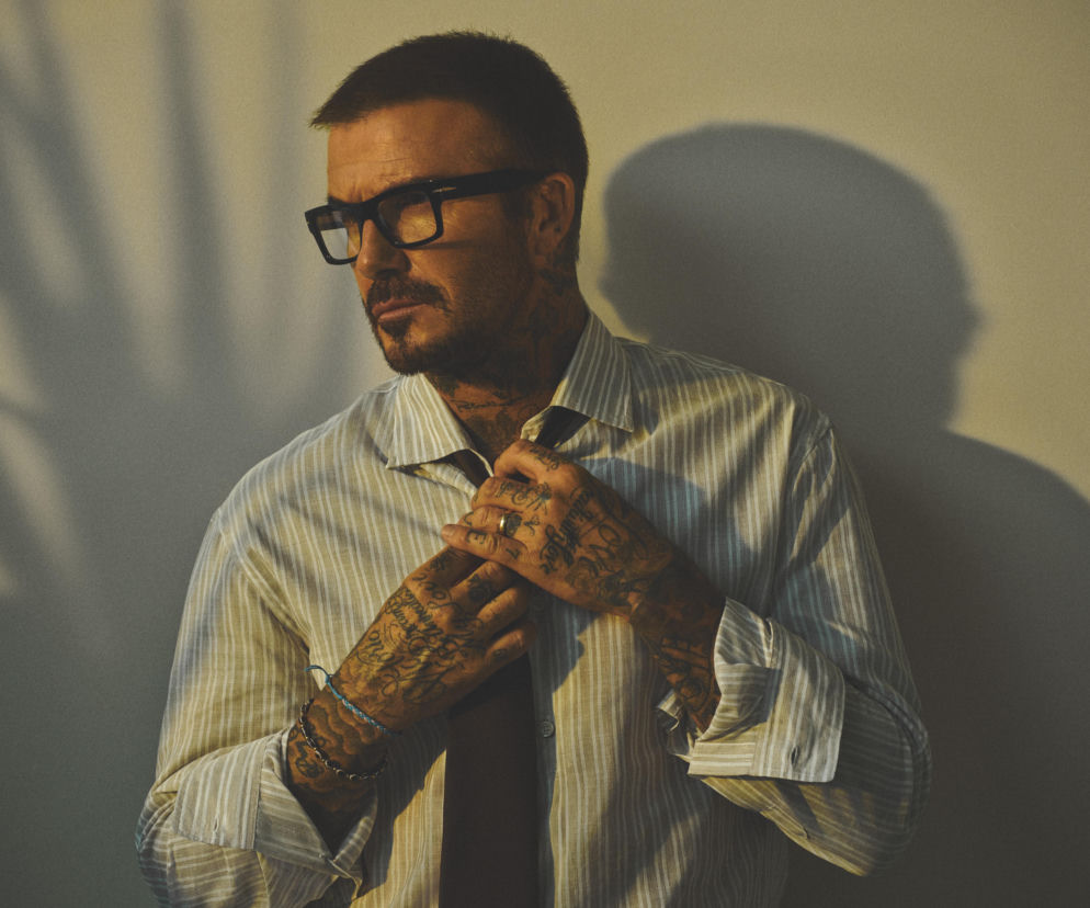 David Beckham w okularach korekcyjnych poprawia krawat. O nowej kolekcji Eyewear by David Beckham przeczytasz na SE.