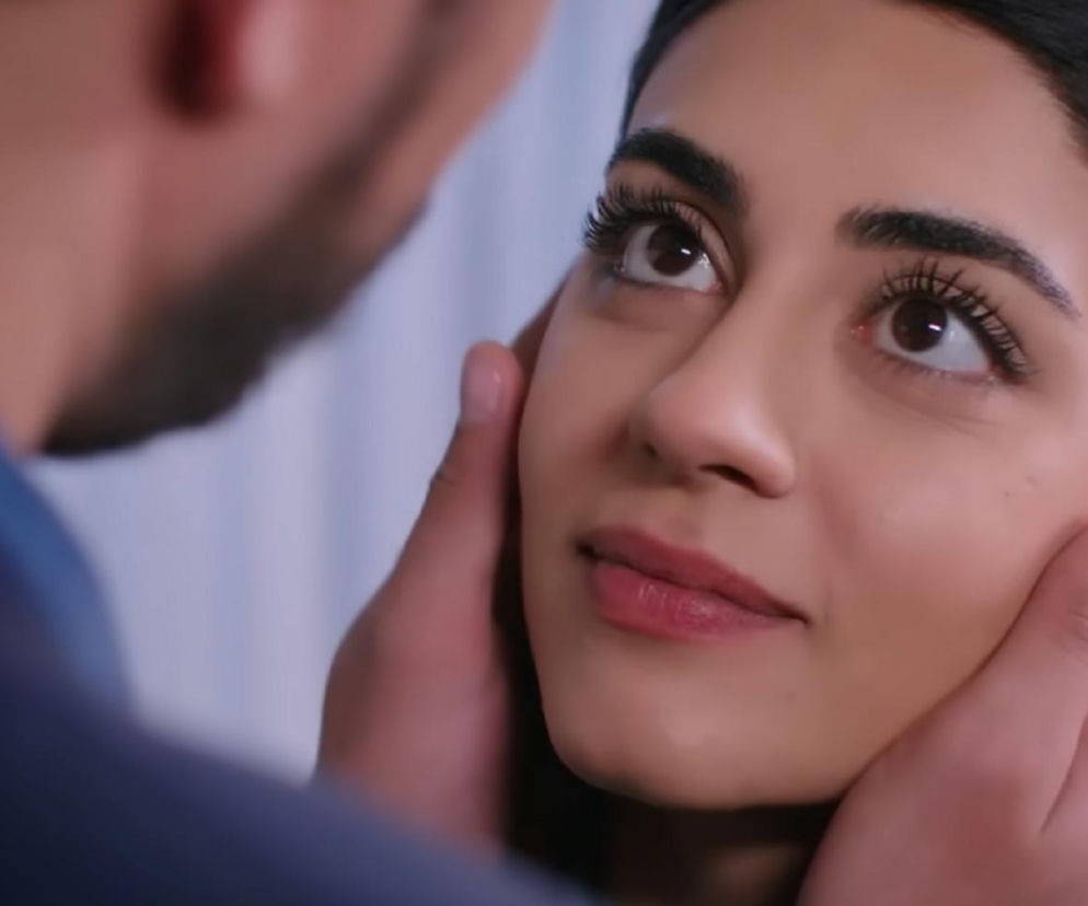 Zbliżenie na twarz Hancer, na której odbijają się głębokie uczucia. Ręka Cihana delikatnie obejmuje jej policzek, co sugeruje intymność i bliskość pary z serialu Panna młoda. Więcej o romantycznych chwilach Cihana i Hancer na Super Seriale.