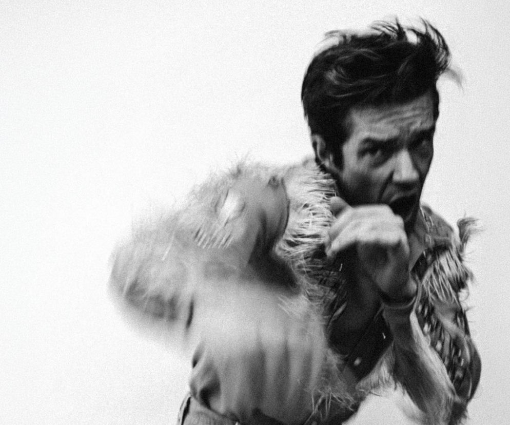 Brandon Flowers w dynamicznej pozie na czarno-białym zdjęciu. O nowym albumie Thrasher przeczytasz na EskaRock.