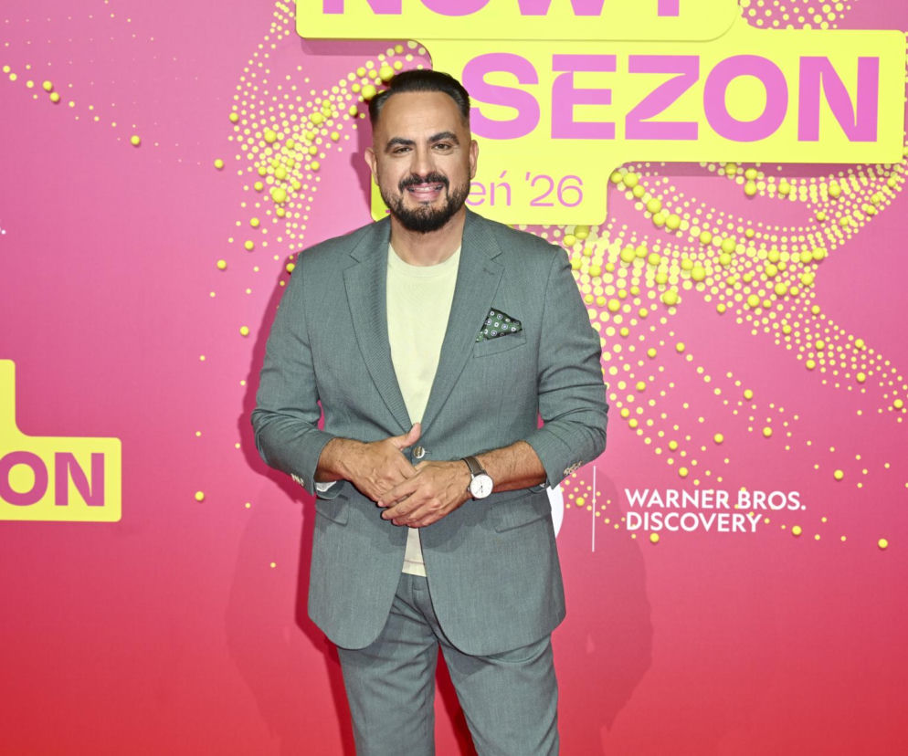 Uśmiechnięty Agustin Egurrola w szarym garniturze na różowym tle ścianki. O jego wymarzonym weselu przeczytasz na Eska.