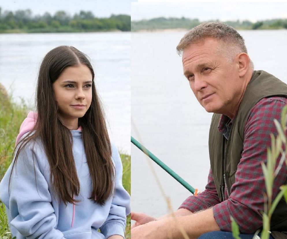 Basia (Karina Woźniak) w jasnoniebieskiej bluzie z kapturem i Artur Rogowski (Robert Moskwa) w koszuli w kratę i kamizelce, siedzący nad wodą podczas wyprawy na ryby w serialu M jak miłość. Zdjęcie ilustruje odcinek 1899, gdzie Basia ukrywa tajemnicę przed ojcem. Więcej o ich relacji i sekretach znajdziesz na Super Seriale.