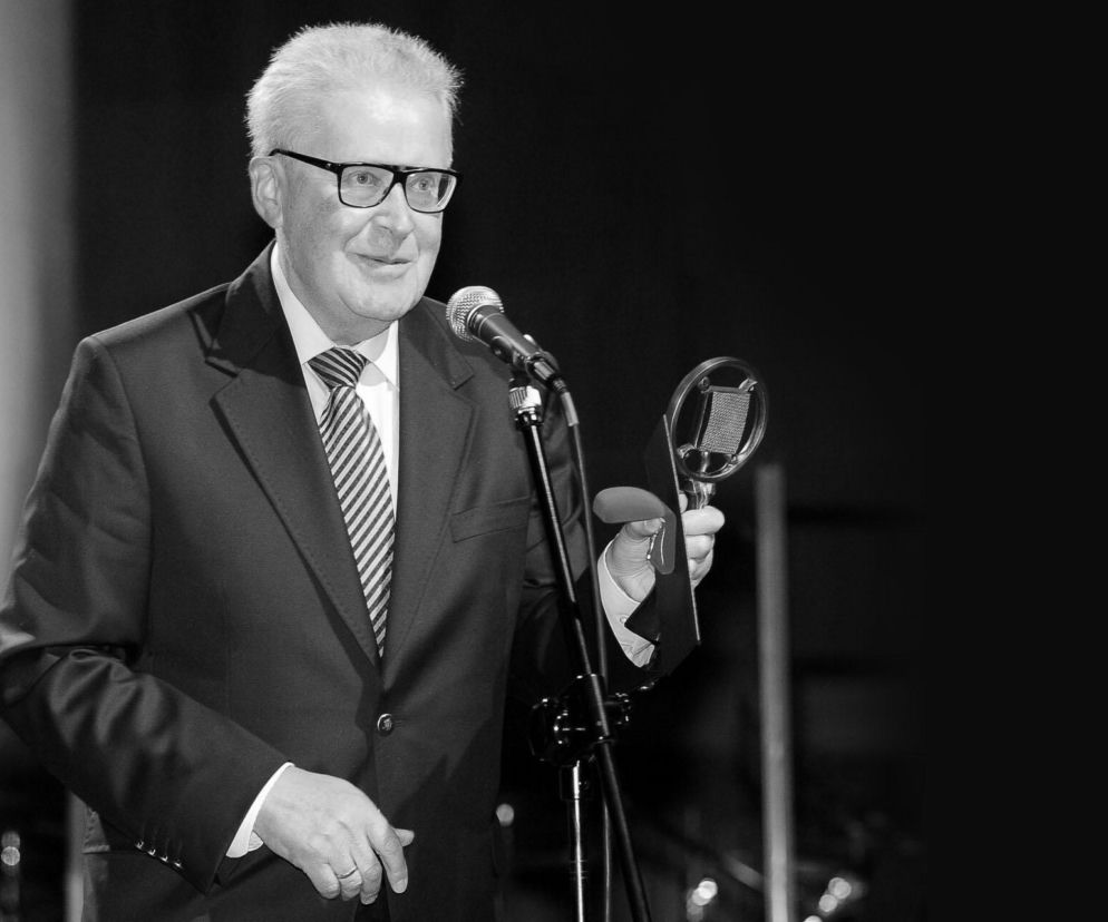 Dziennikarz Wiktor Legowicz w garniturze trzyma mikrofon i statuetkę. O śmierci legendy Trójki przeczytasz na SE.