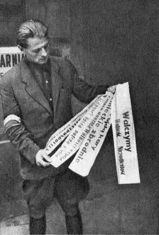 Por. Roman Rozmiłowski ps. Zawada (1915-1944), prezentuje afisze powstańcze, sierpień 1944.