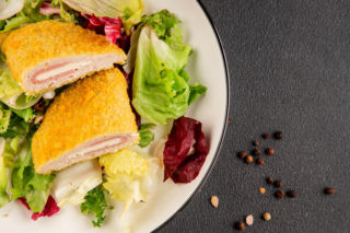 Kotlet cordon bleu. Chrupiąca panierka skrywa środek, który rozpływa się po przekrojeniu