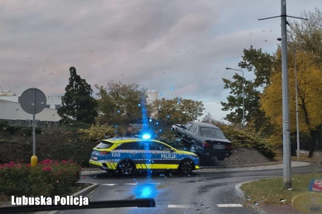 Radiowóz policyjny na sygnale obok czarnego BMW, które wjechało na środek ronda. O zdarzeniu w Nowej Soli informuje Eska Zielona-Góra.