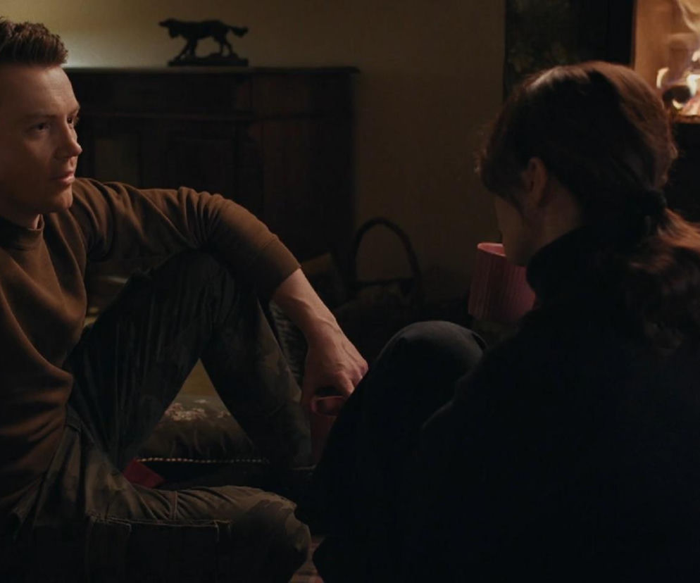 Jakub (Krzysztof Kwiatkowski) i Martyna (Magdalena Turczeniewicz) siedzą na podłodze przy kominku, prowadząc szczerą rozmowę. Jakub w brązowym swetrze patrzy na Martynę, która siedzi do niego tyłem. Romantyczna scena z serialu M jak miłość na portalu Super Seriale.