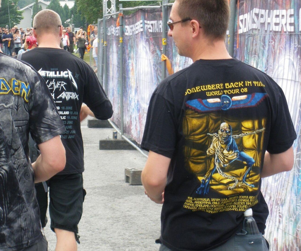 Mężczyźni w koszulkach Iron Maiden i Metalliki na festiwalu. O noszeniu merchu zespołów przeczytasz na EskaRock.