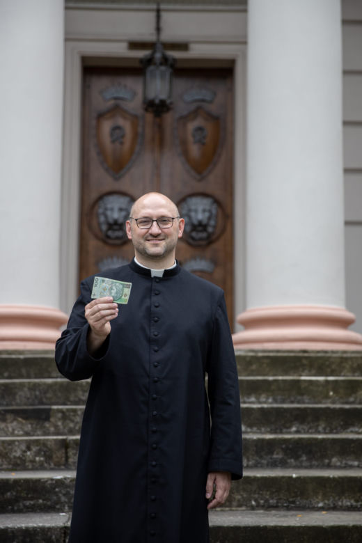 Ksiądz rozdaje pieniądze na mszy