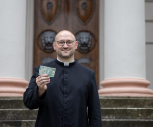 Ksiądz rozdaje pieniądze na mszy