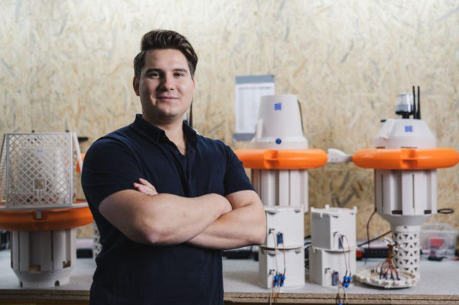 Filip Budny, laureat Nagrody Jamesa Dysona 2025 w kategorii zrównoważonego rozwoju, uśmiecha się na tle swoich prototypów WaterSense do monitorowania jakości wody. O jego innowacyjnym wynalazku można przeczytać na portalu Architektura Murator Plus.