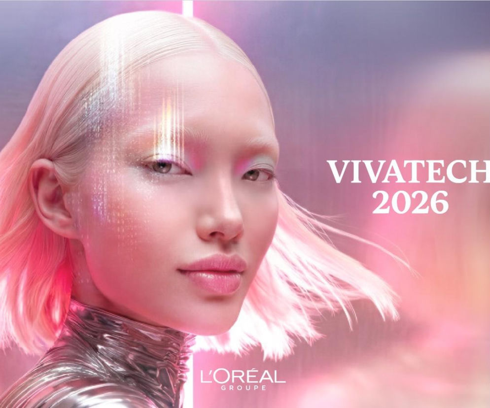 Młoda kobieta z jasnoróżowymi włosami i futurystycznym makijażem, z cyfrowymi elementami na twarzy, symbolizująca innowacje L'Oréal w beauty tech. W tle rozmyte, różowo-fioletowe światła. Na zdjęciu widoczny napis VIVATECH 2026 oraz logo L'Oréal Groupe. Artykuł o przyszłości branży beauty na naszym portalu.