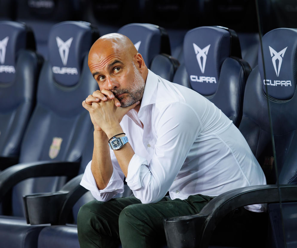 Pep Guardiola siedzący na ławce rezerwowych w zamyślonej pozie. O przyszłości trenera Włoch przeczytasz na VOX FM.