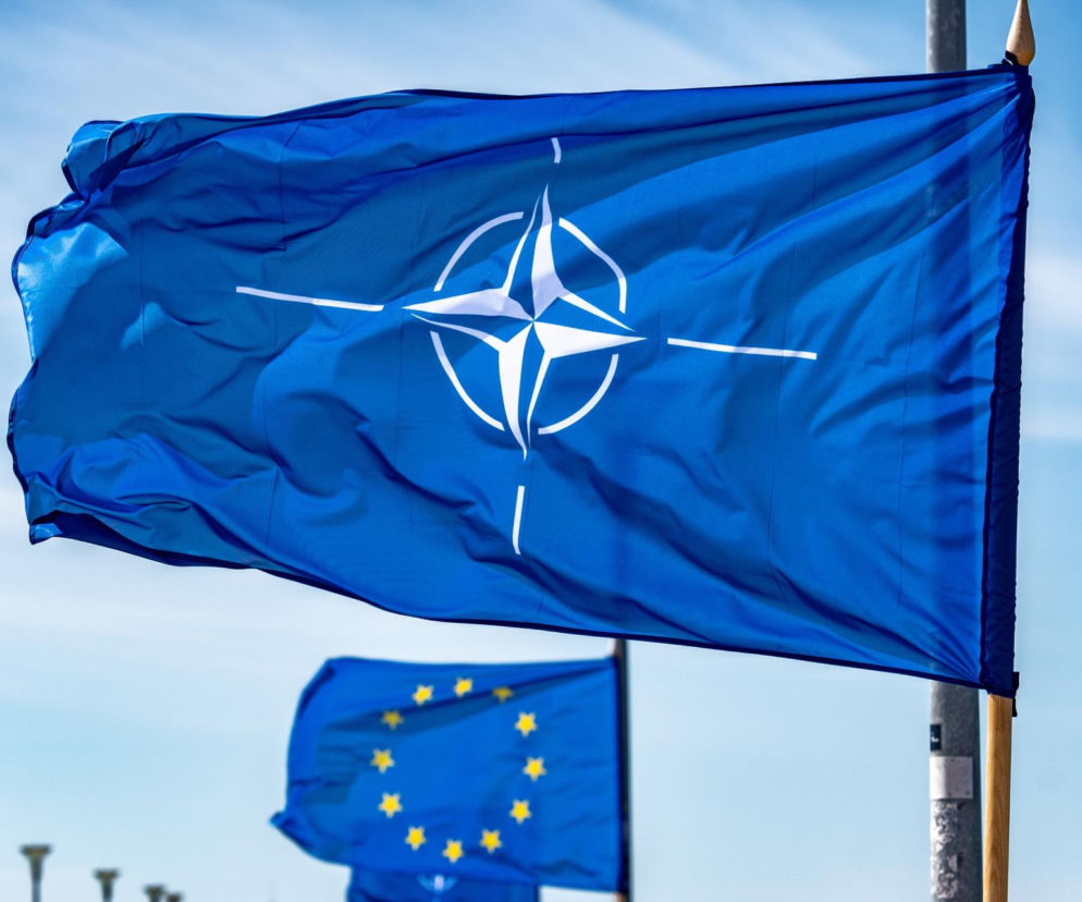 Flaga NATO na tle nieba. Obok flaga Unii Europejskiej. O reakcji sojuszu na incydent w Polsce przeczytasz w serwisie Eska.