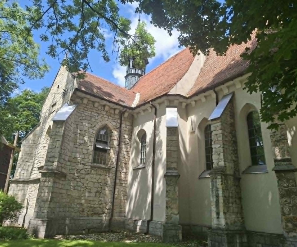 Murowany kościół w Chrobrzu otoczony zielonymi drzewami. O historii tej wsi przeczytasz na Eska Starachowice.