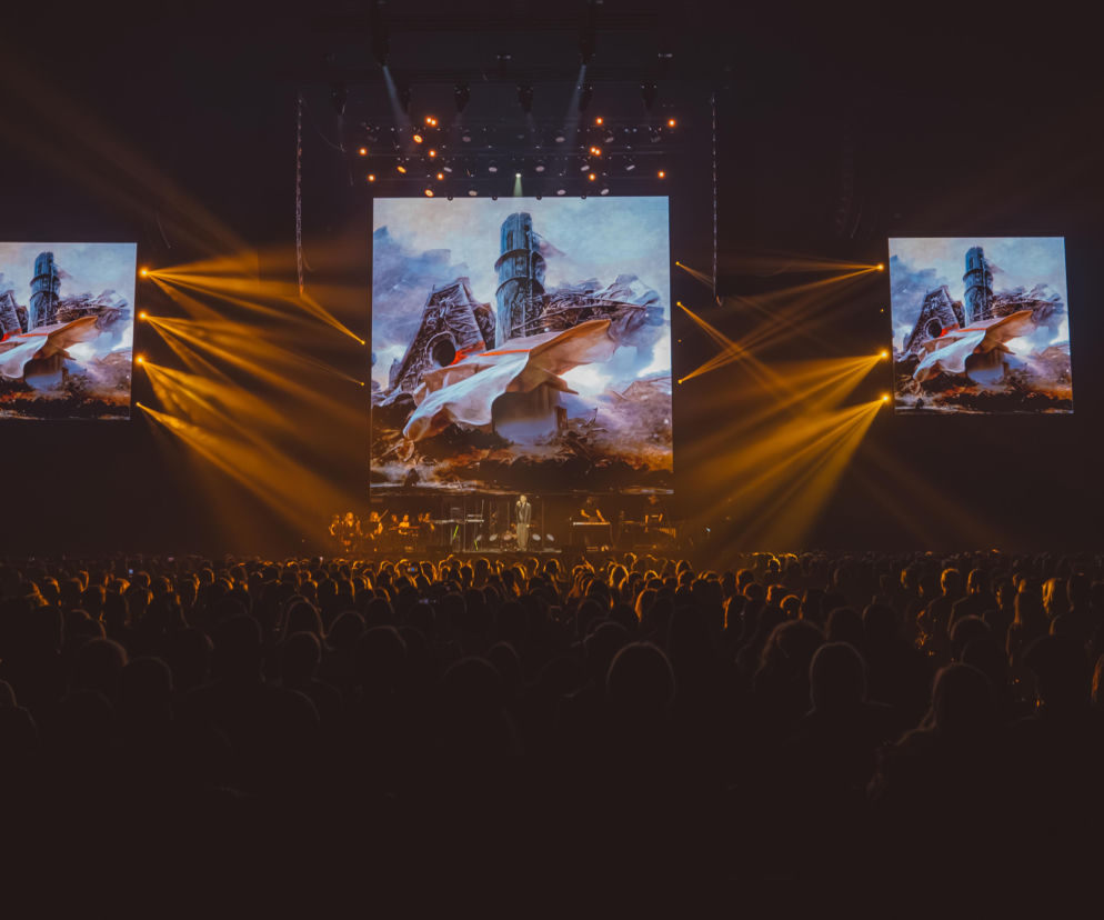 Publiczność ogląda spektakl Beksiński Live. Na ekranach ożywione obrazy artysty. O finale widowiska przeczytasz w Eska.