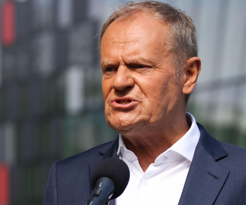 Premier Donald Tusk przemawia do mikrofonu. O szczegółach afery w Orlenie przeczytasz na SE Superbiz.