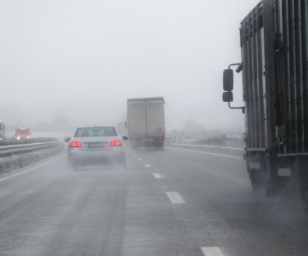 Samochody na zamglonej, wilgotnej drodze w grudniu, co symbolizuje niebezpieczne warunki pogodowe i ryzyko dla zdrowia. Poradnik Zdrowie przestrzega przed zmienną aurą, która sprzyja infekcjom i problemom krążeniowym, szczegóły na portalu.