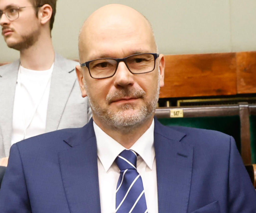 Maciej Berek w ciemnoniebieskim garniturze i krawacie siedzi w ławach poselskich. O jego apelu przeczytasz na SE Polityka.