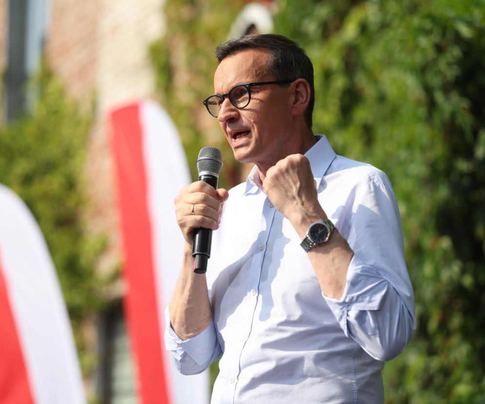 Mateusz Morawiecki przemawia do mikrofonu z zaciśniętą pięścią. O jego planach migracyjnych przeczytasz na SE Polityka.