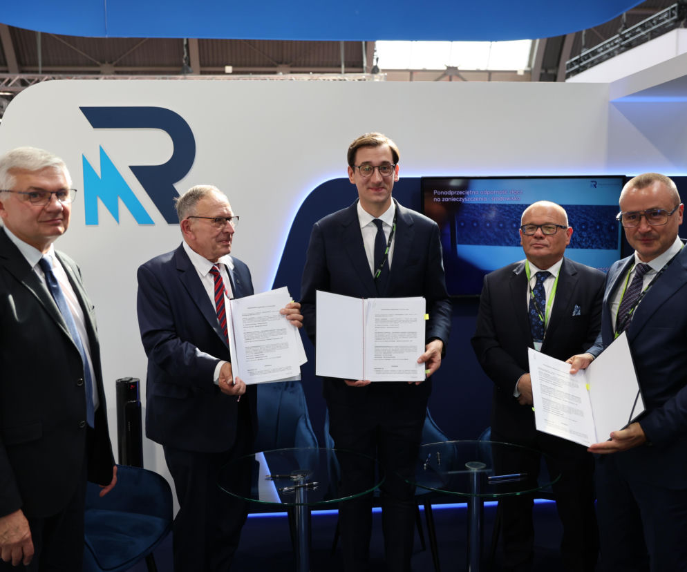 Mężczyźni z dokumentami podczas targów MSPO. O współpracy Łukasiewicza i Radiotechniki pisze SE Portal Obronny.