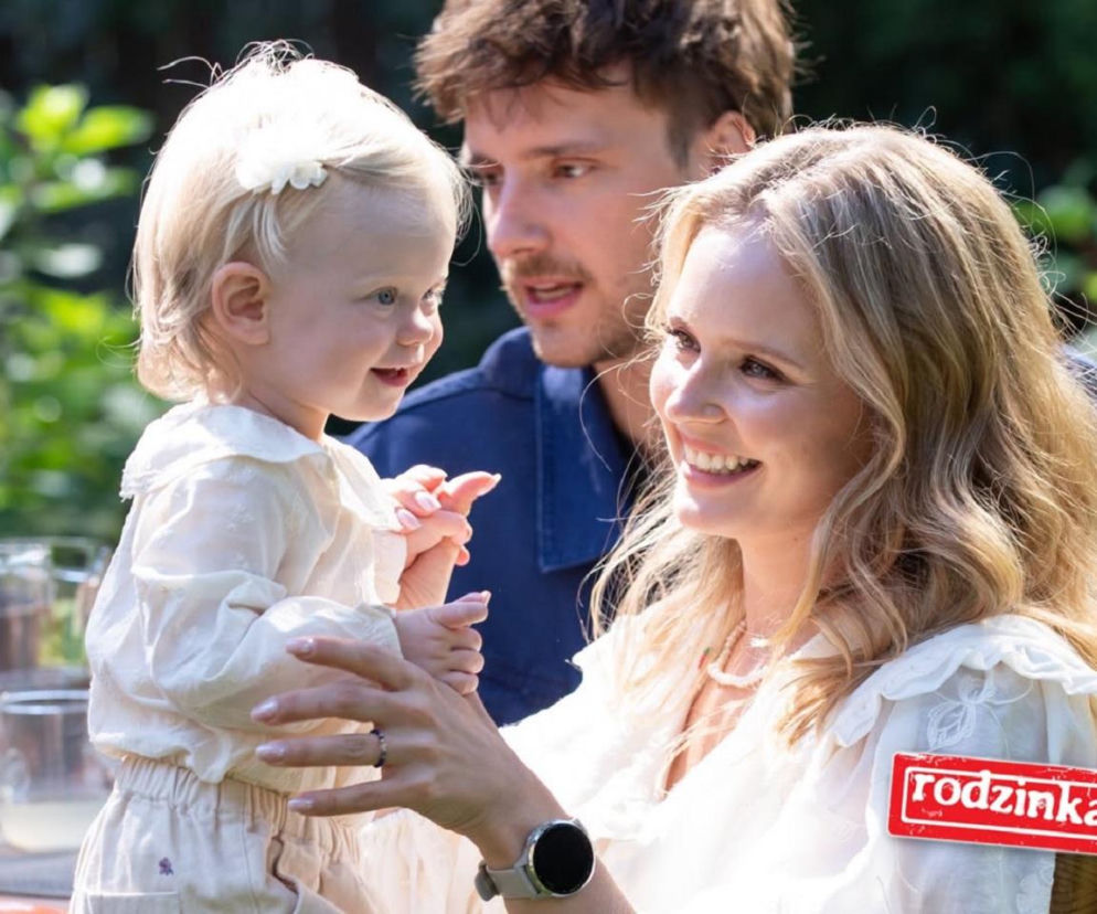 Uśmiechnięta Olga Kalicka trzyma małą córkę, obok Maciej Musiał. O serialu Rodzinka.pl przeczytasz na SE Superseriale.