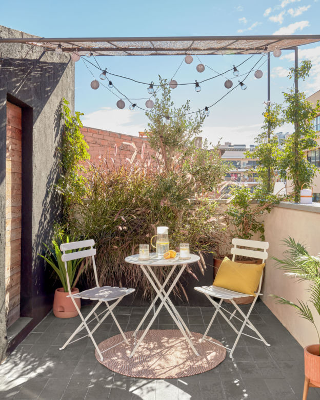 Mały balkon w bloku lub kamienicy ze światełkami