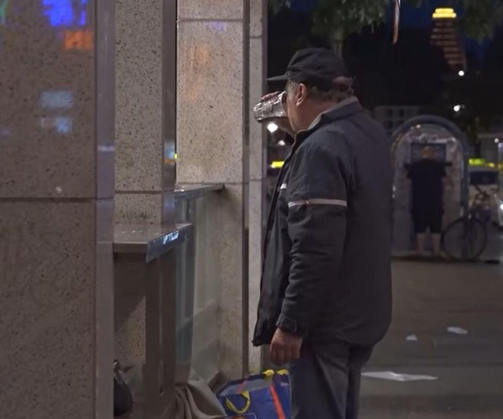 Mężczyzna w ciemnej kurtce pije z puszki na ulicy Berlina. O losach bezdomnych Polaków przeczytasz w Mediateka.