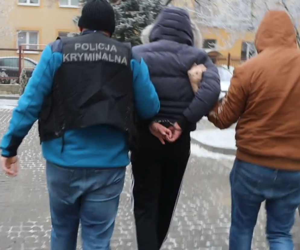Screen z filmu z doprowadzania przez policjantów jednego z podejrzanych