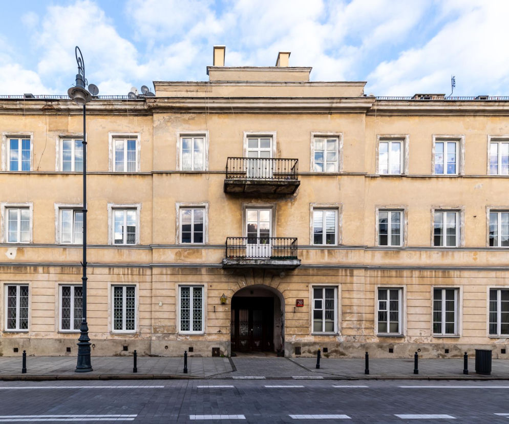 Dwupiętrowa kamienica na Miodowej 20 w Warszawie, odbudowana po wojnie zgodnie z pierwotnym projektem, z brązowymi drzwiami wejściowymi w łukowym portalu i dwoma żelaznymi balkonami, świadczy o burzliwej historii. Więcej o architekturze tego typu na Architektura Murator Plus.