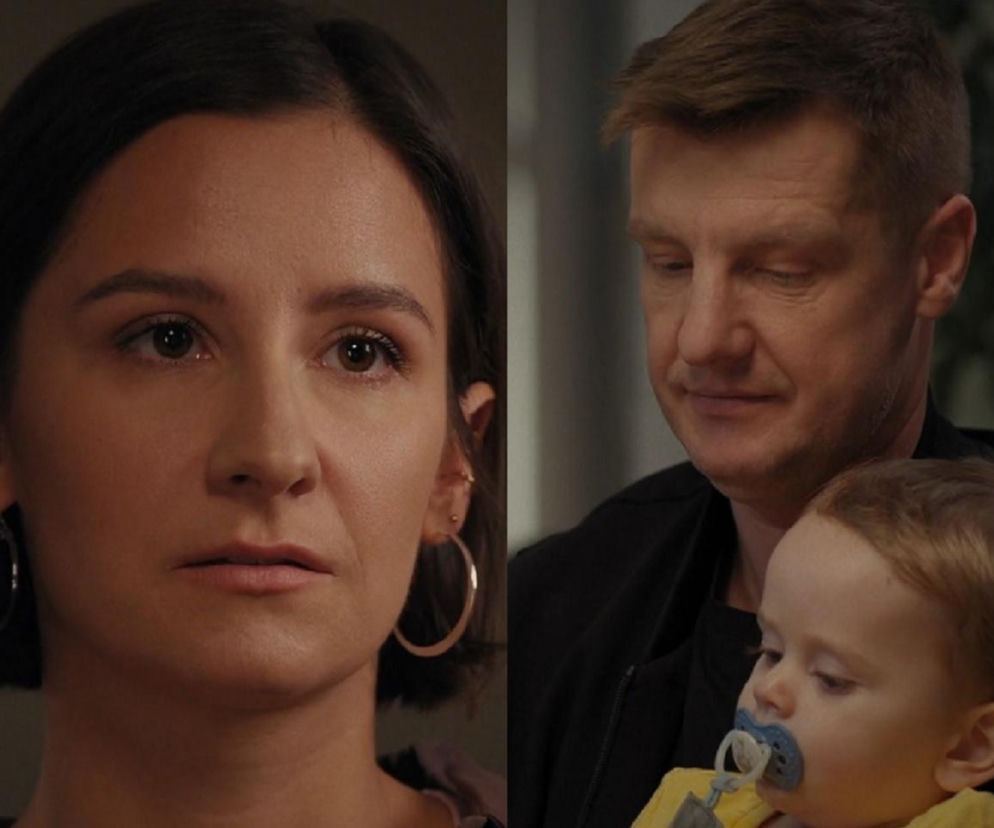 Amanda Mincewicz jako Agnes, patrząca smutno w bok. Obok niej Rafał Mroczek jako Paweł Zduński, trzymający na rękach Mikołaja Jankowskiego jako Antosia, z miną pełną zadumy. To kadr z serialu M jak miłość. Więcej o tym na stronie Super Seriale.