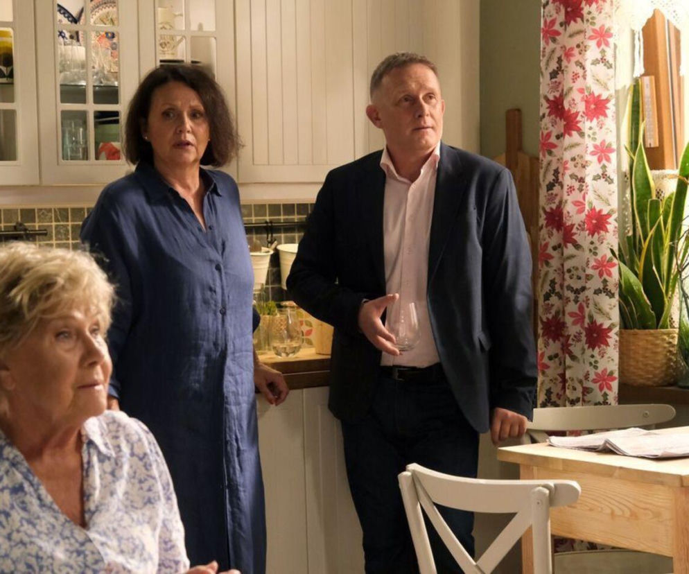 Barbara (Teresa Lipowska), Marysia (Małgorzata Pieńkowska) i Artur Rogowski (Robert Moskwa) z M jak miłość w kuchni. Barbara, siedząca na pierwszym planie, w jasnej bluzce w niebieskie wzory, patrzy w prawo. Marysia, w granatowej sukience koszulowej, stoi z tyłu po lewej, a Artur w marynarce, trzymając szklankę, stoi po prawej, patrząc w górę. O nadchodzącym sezonie przeczytasz na Super Seriale.