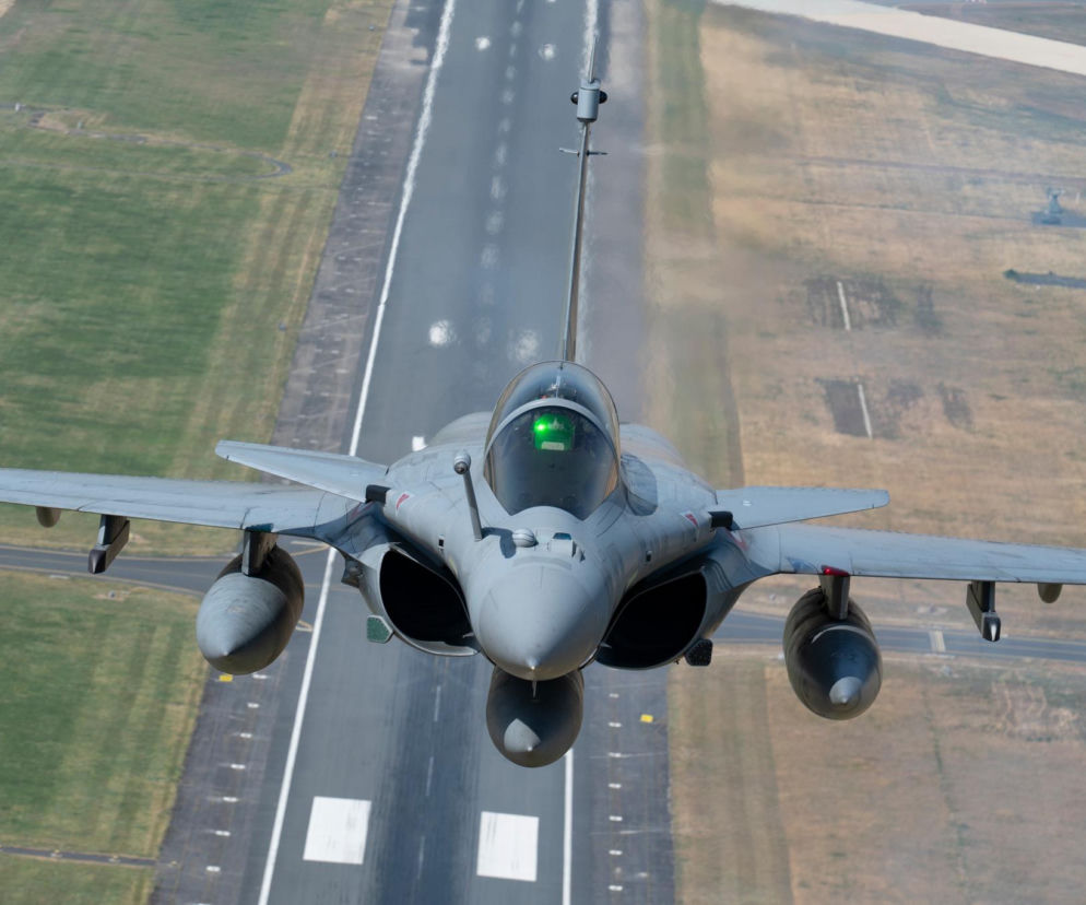 Francuski myśliwiec Rafale leci nisko nad pasem startowym lotniska. O misji NATO przeczytasz na SE Portal Obronny.