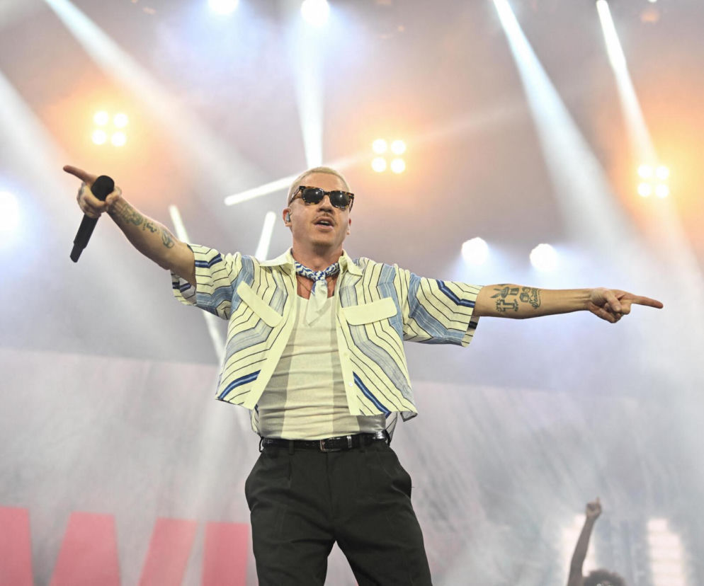 Macklemore śpiewa na scenie z mikrofonem w dłoni. O występie rapera na festiwalu w Poznaniu przeczytasz na SE.