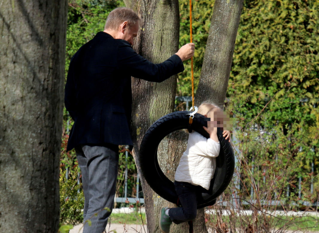 Donald Tusk z wnuczka na placu zabaw