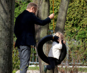Donald Tusk z wnuczka na placu zabaw