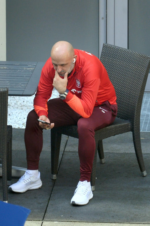 Michał Probierz przybity wpatruje się w telefon