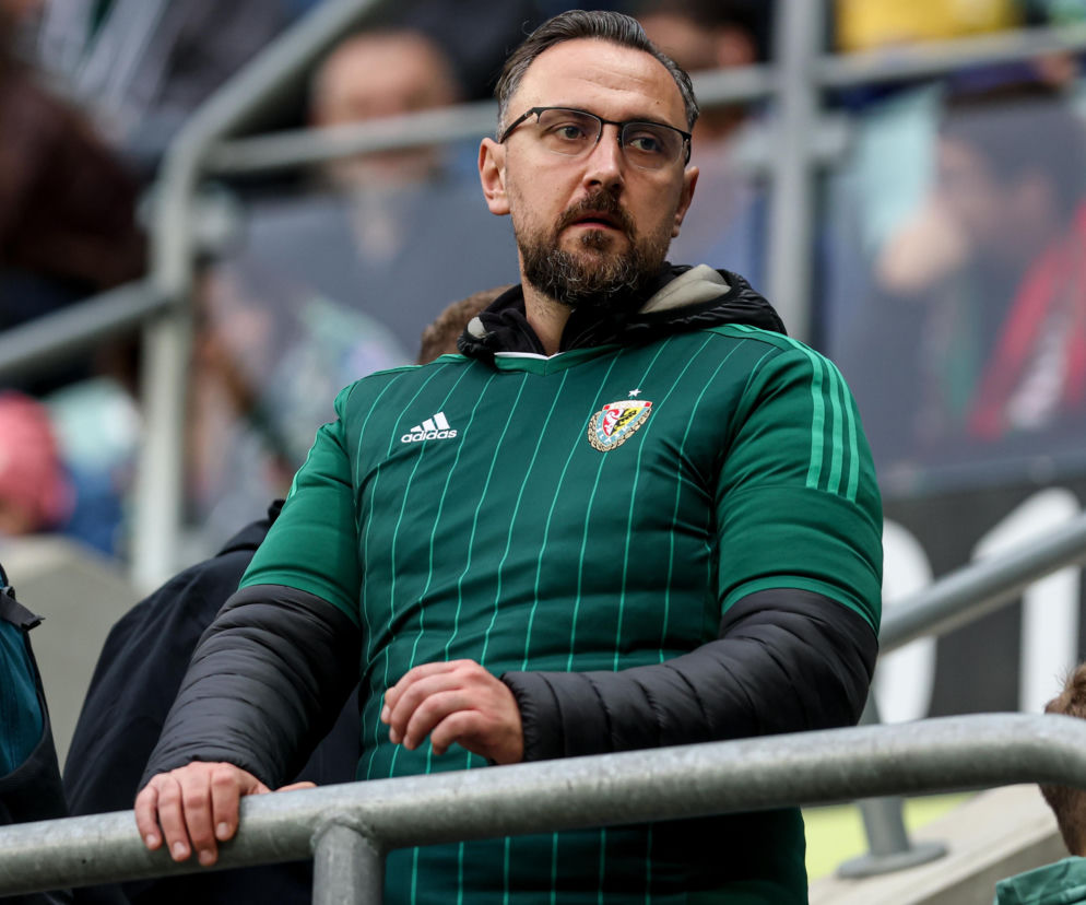 Kibic w okularach i zielonej koszulce Śląska Wrocław na trybunach stadionu. O meczu z Lechem przeczytasz na Eska Wrocław.