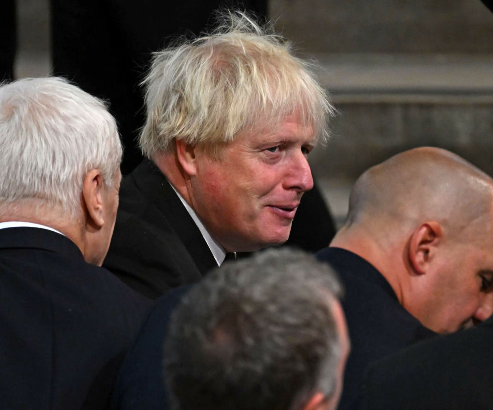 Boris Johnson z przejętą miną siedzi wśród innych osób. O ewakuacji polityka z pociągu przeczytasz w serwisie Eska.