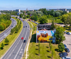 Otoczony reklamami dom przy Dolinie Służewieckiej w Warszawie