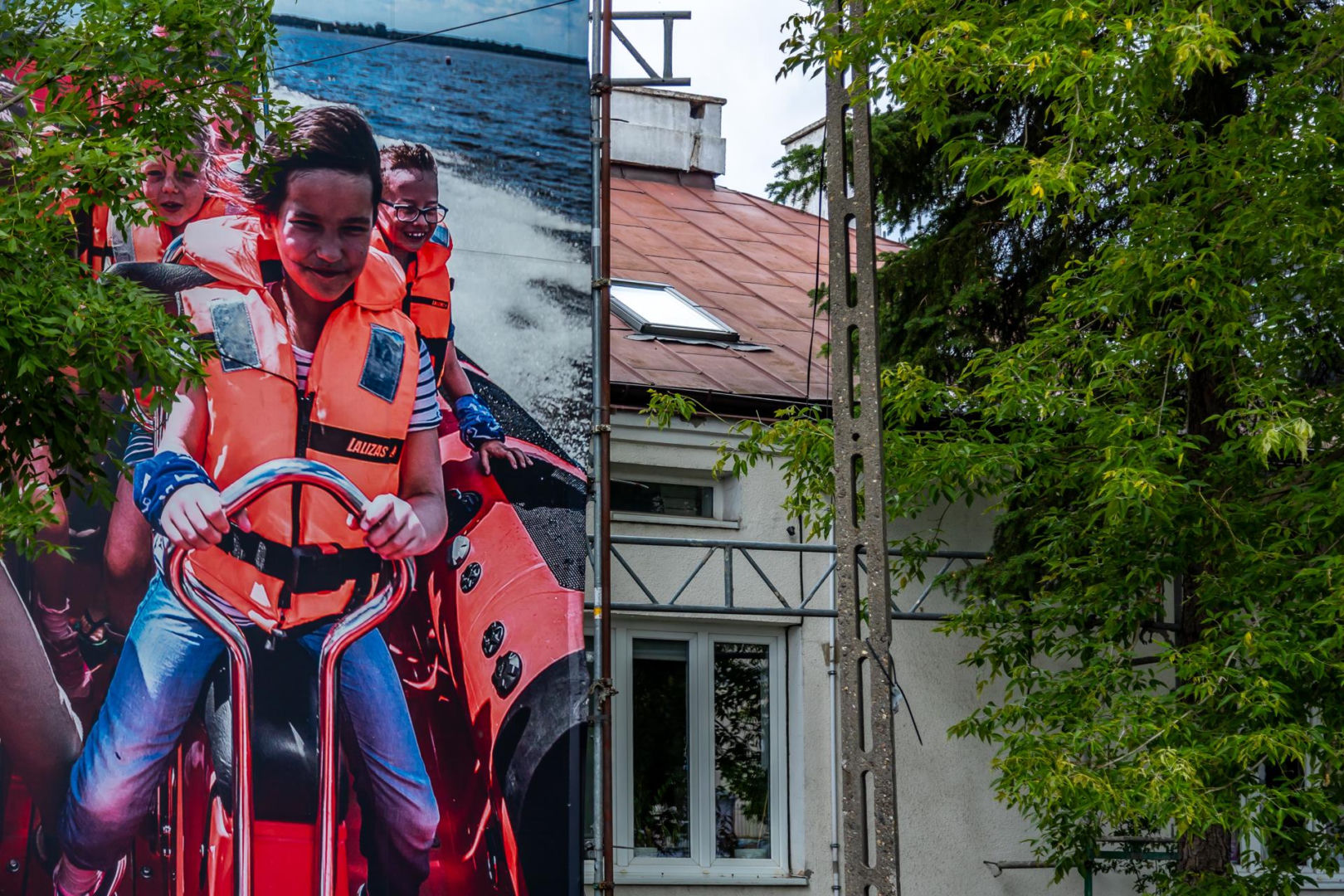 Otoczony reklamami dom przy Dolinie Służewieckiej w Warszawie