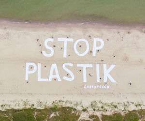 Wielki napis Stop plastik na plaży w Kołobrzegu
