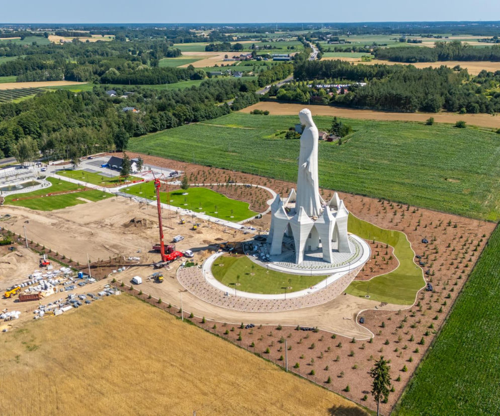 Wysoki biały pomnik Matki Boskiej na postumencie w budowie w Konotopiu. O inwestycji przeczytasz na Architektura.