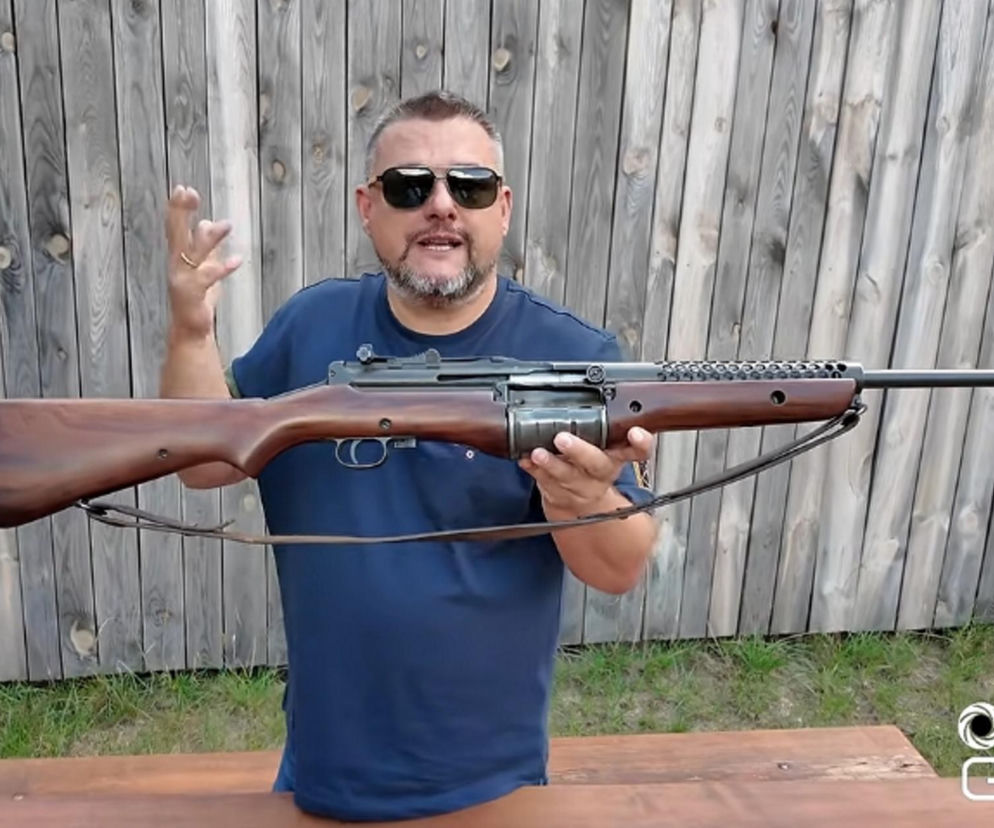 Mężczyzna w ciemnych okularach trzyma karabin Johnson M1941. O historii tej broni przeczytasz na SE Portal Obronny.