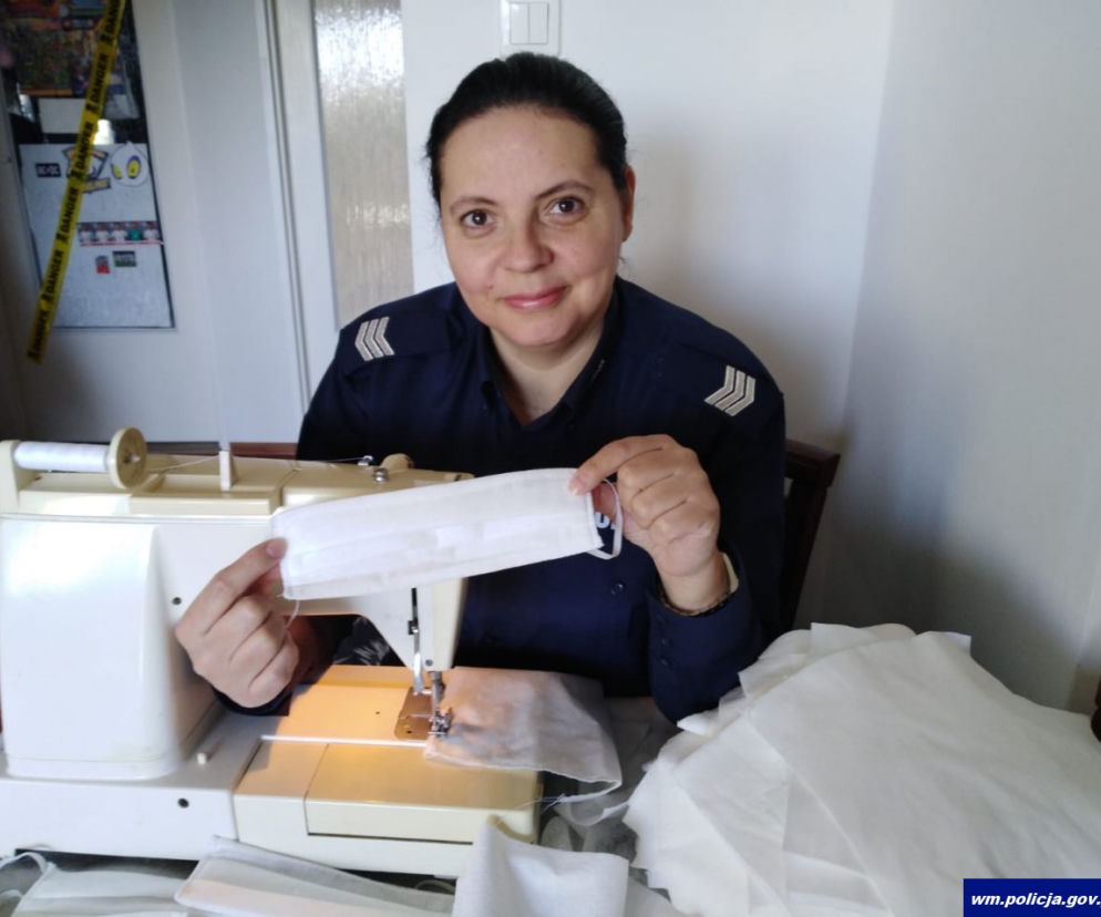 Policjantka z piskiej komendy sierż. szt. Małgorzata Księżyk szyje maseczki ochronne